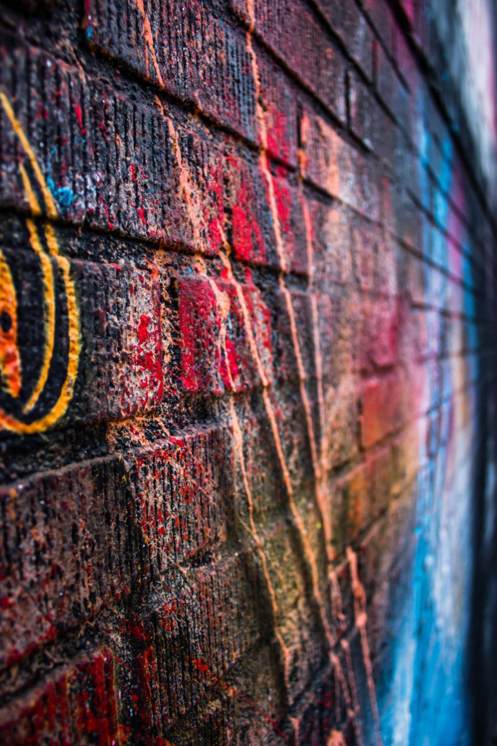Free Image of Close-up of a colorfully painted brick wall with abstract textures. 