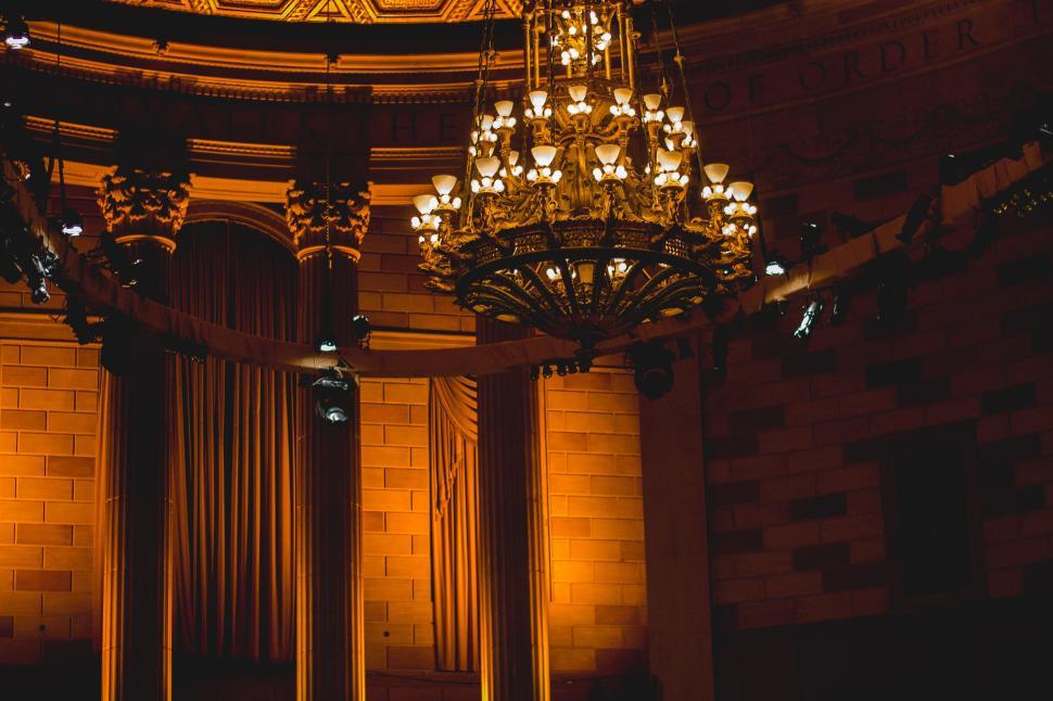 Free Image of Lavishly decorated interior with a grand chandelier and draped lights. 