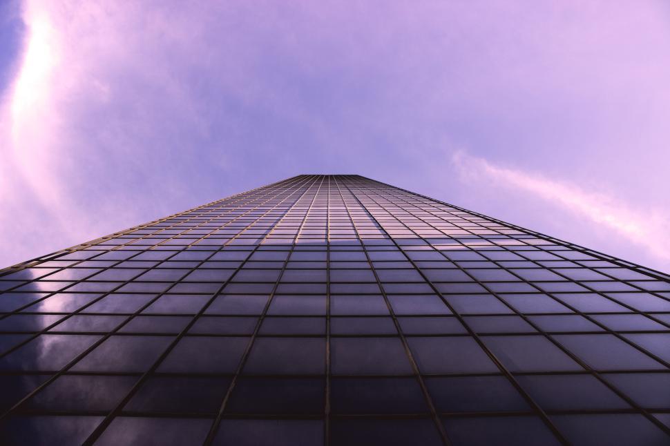 Free Image of Looking up a glass skyscraper to a purple sky with a unique angle 