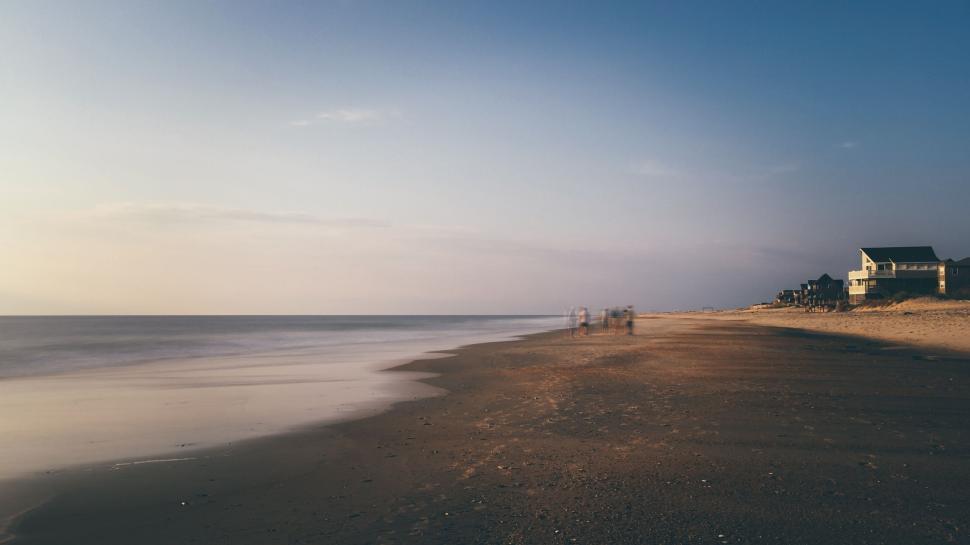 Free Image of Calm evening at the beach with a house and serene surroundings. 