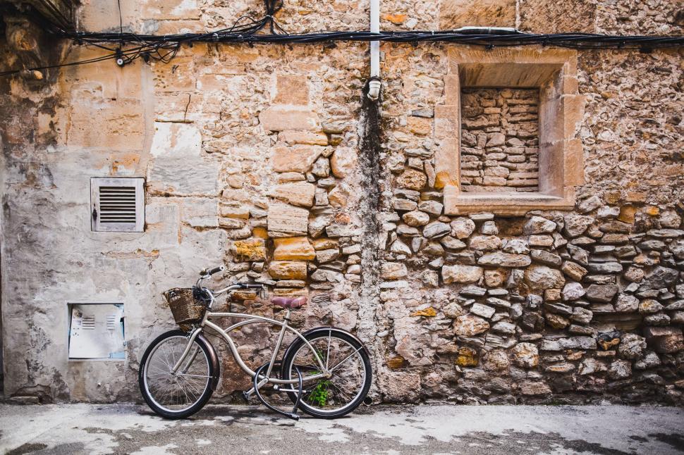Free Image of Classic bicycle leaning against a stone wall in an old street. 