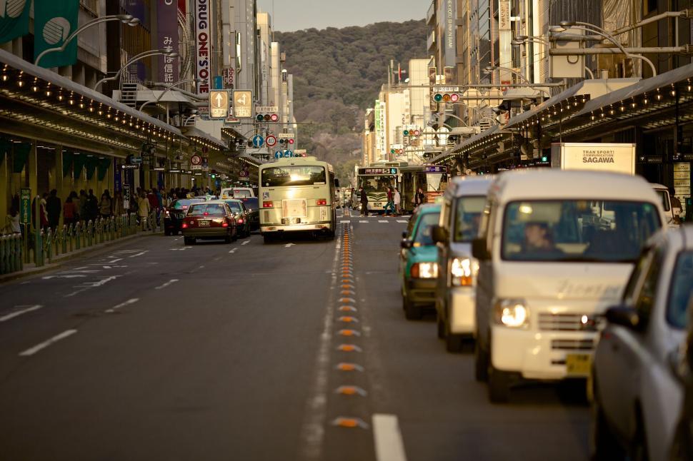 Free Image of Bustling city street filled with traffic and buildings on each side 