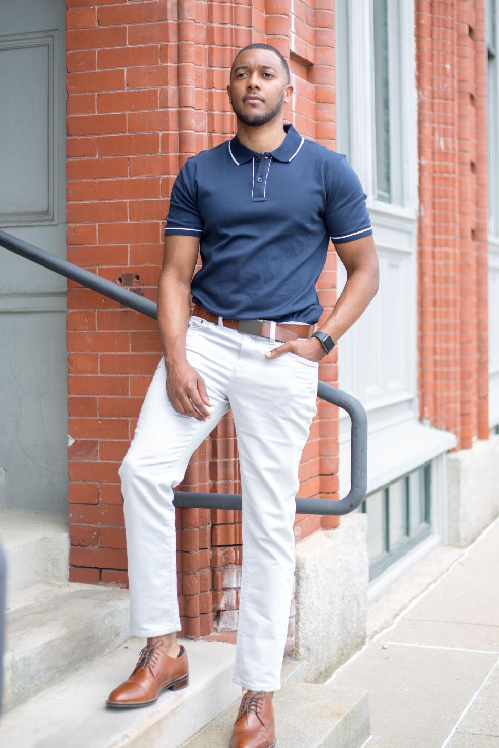 Free Image of Stylish man standing on steps in urban setting in cool outfit 