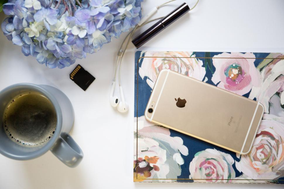 Free Image of IPhone, coffee, notebook, hydrangeas and SD card on a desk. 