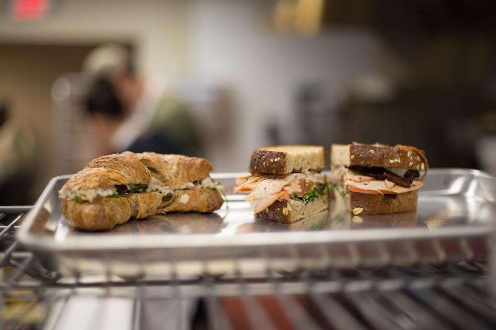 Free Image of Croissant and sandwich halves are displayed on a silver tray. 