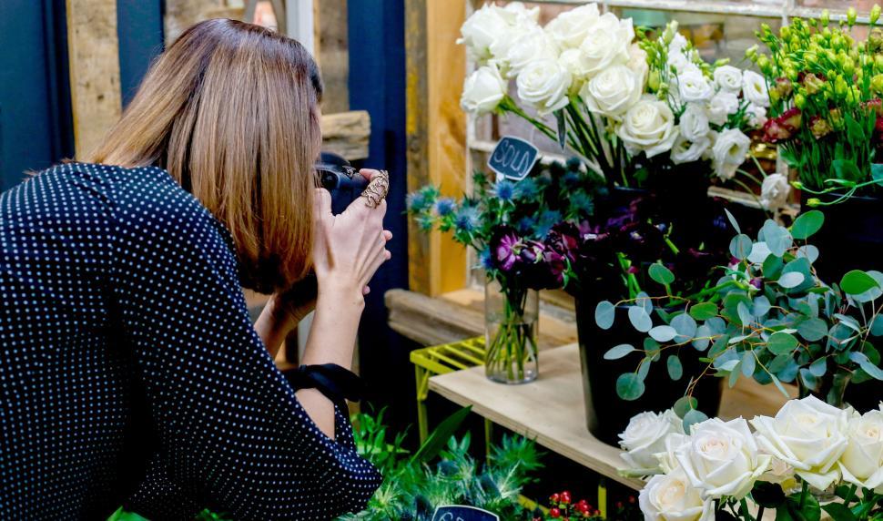 Free Image of Photographer capturing a bouquet of flowers at a flower shop. 