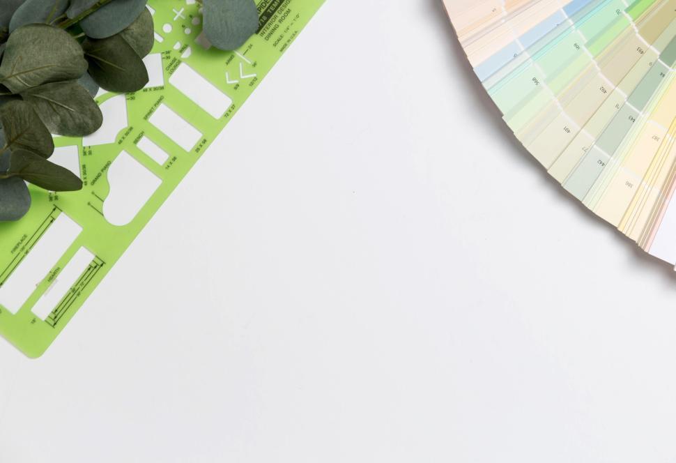 Free Image of Green stencil and color swatches with eucalyptus leaves on white 