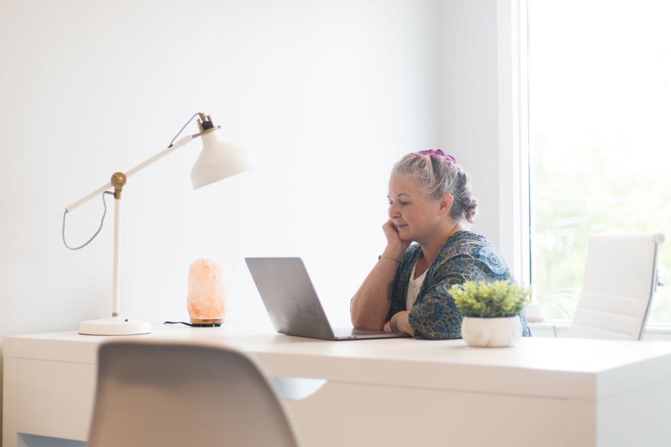 Free Image of Person working on laptop in modern home office environment 