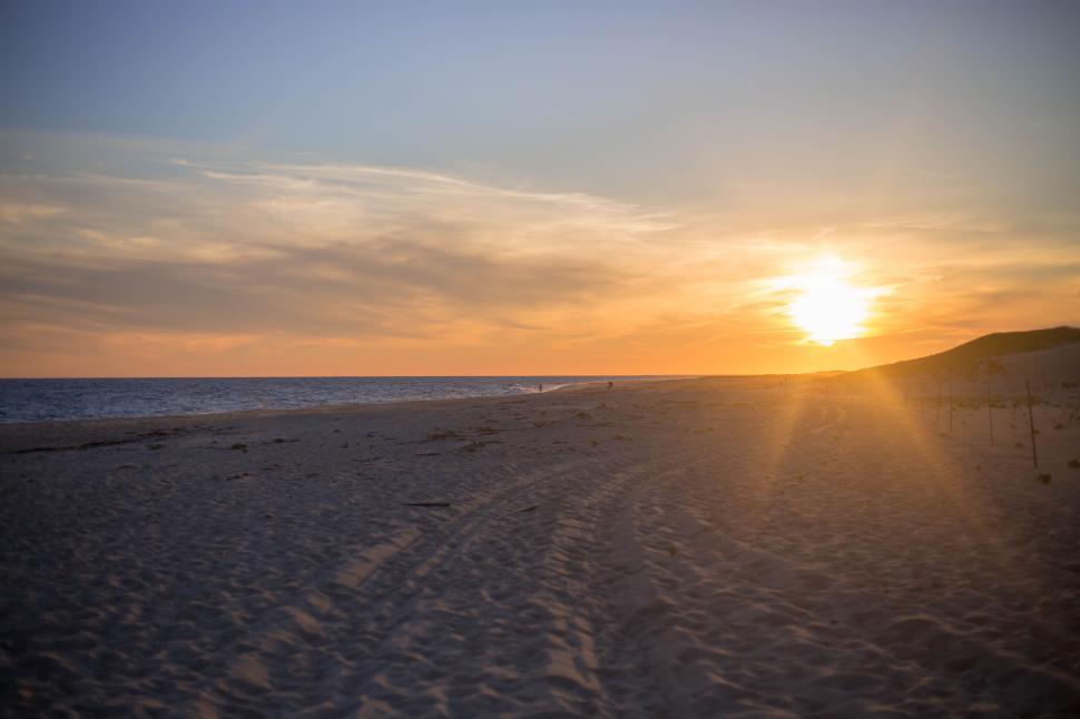 Free Image of Serene beach at sunset with stunning horizon and clear skies 