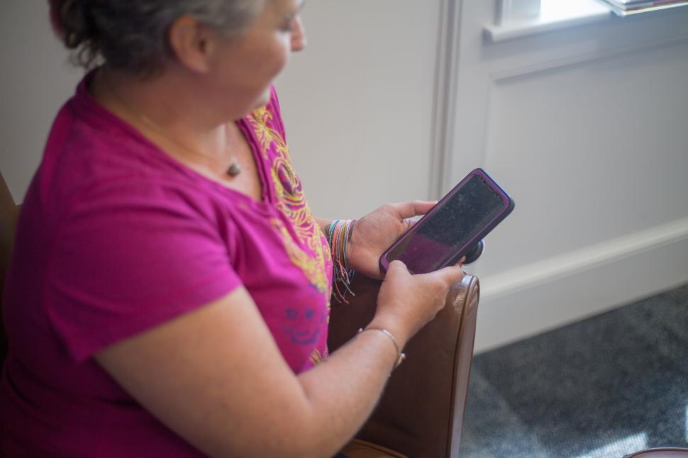 Free Image of Person holding a smartphone, engaging in digital activity, indoors 