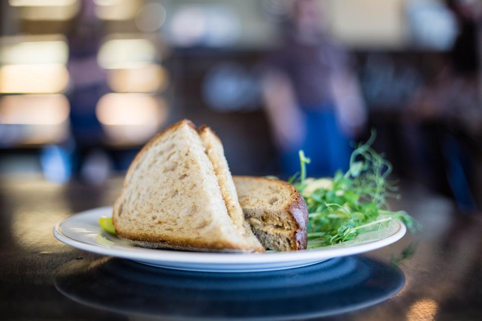 Free Image of Close-up of a fresh sandwich with greens served on a white plate 
