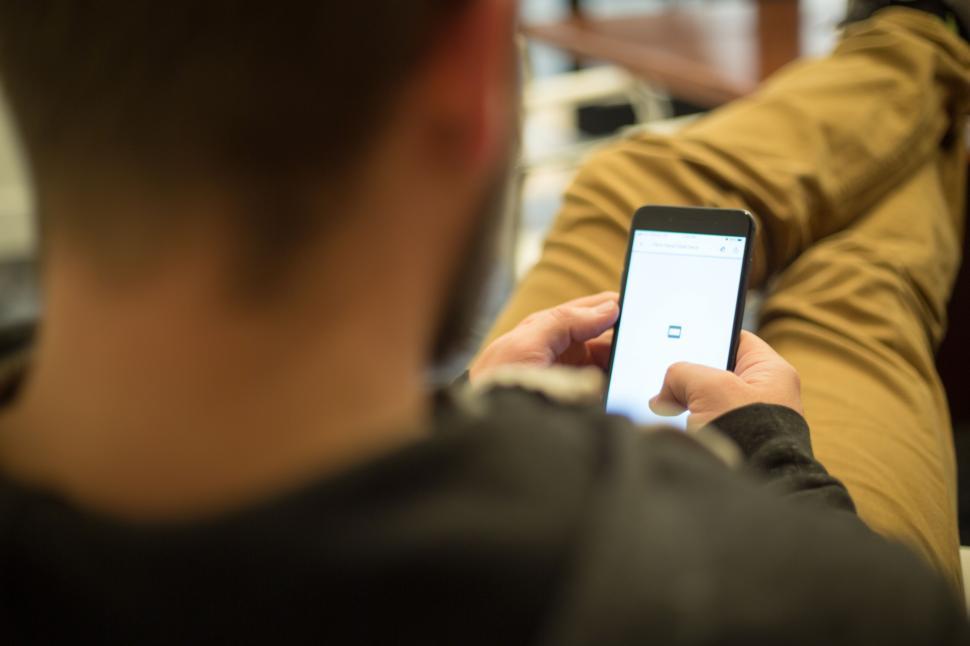 Free Image of Man using smartphone while lounging in casual, relaxed manner 