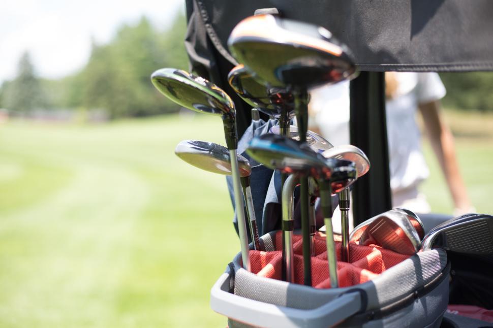 Free Image of Golf clubs arranged in a bag on a golf course with green grass 