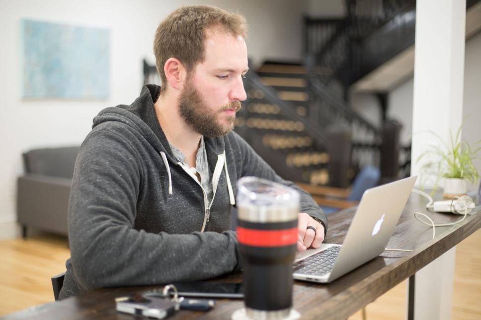 Free Image of Man working on a laptop in a modern open office space 