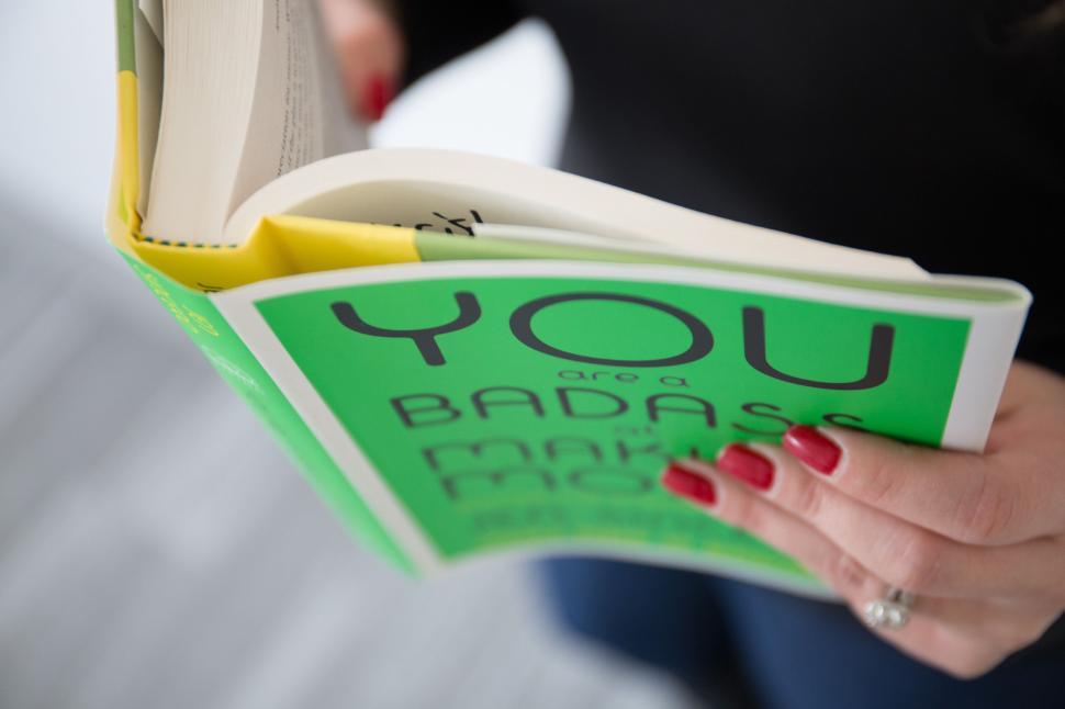 Free Image of Reading self-help book titled  You are a badass at making money 