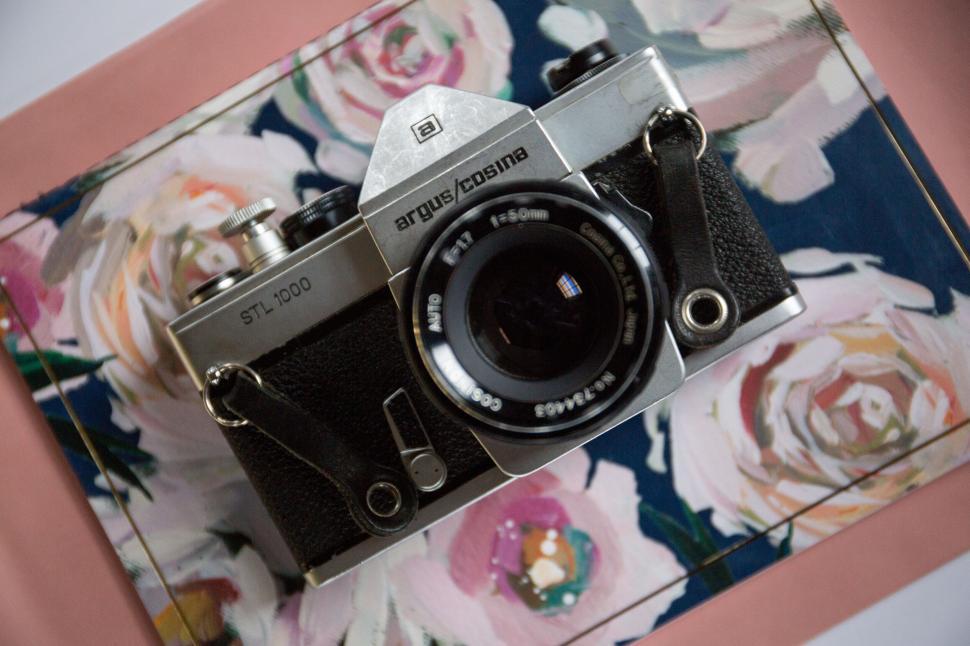 Free Image of Vintage Argus Cosina STL-1000 camera placed on a floral background. 