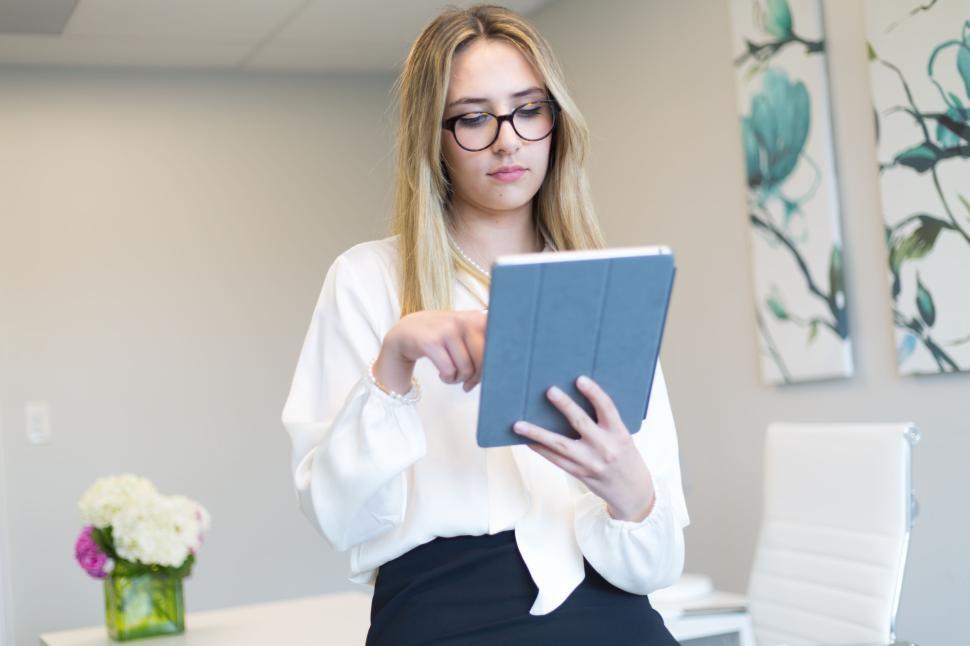Free Image of Blonde woman focusing on tablet, working in a stylish office 