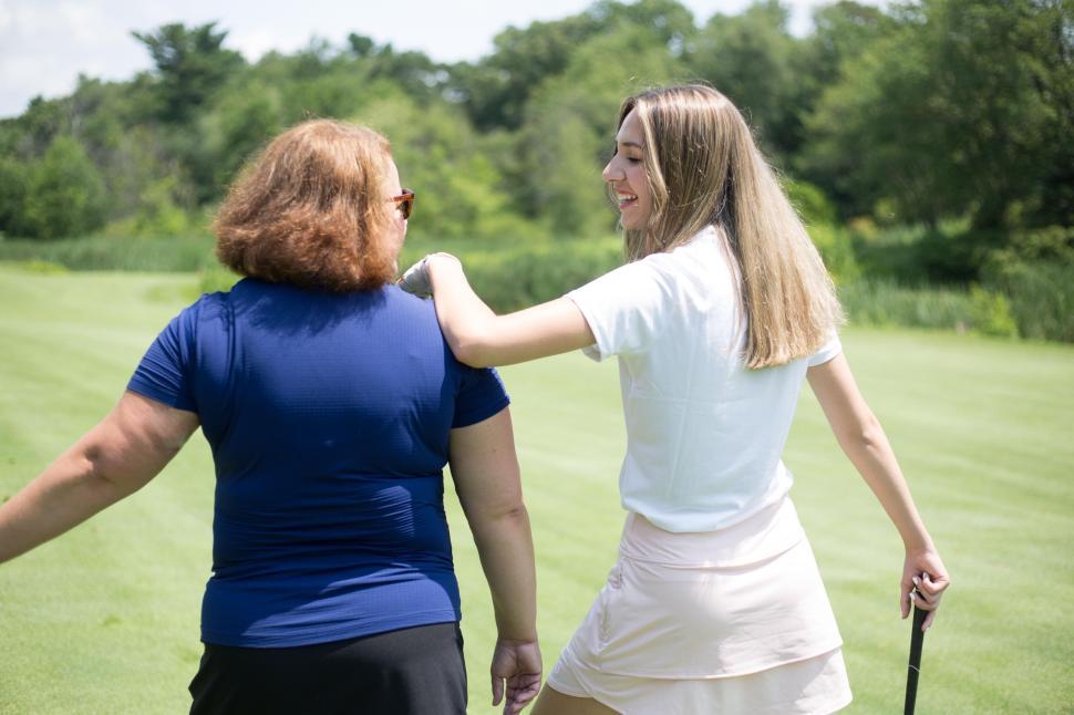 Free Image of Two people enjoying a moment together on a green golf course. 