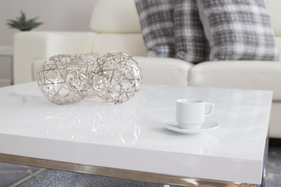 Free Image of White coffee cup on a modern white table with decorative spheres 