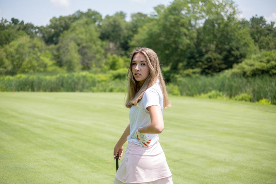 Free Image of Young woman with golf club standing on well-manicured lawn 