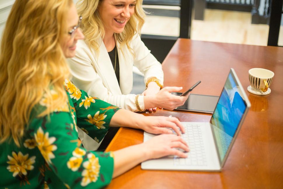 Free Image of Two women collaborating on a laptop in professional setting 