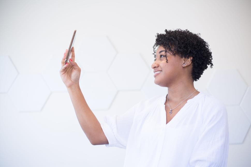 Free Image of Person Taking a Selfie Against a White Hexagonal Wall 