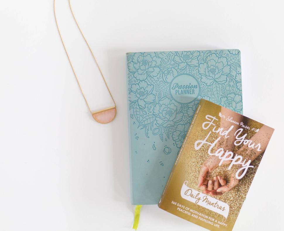 Free Image of Passion planner with gold necklace and book on white background 