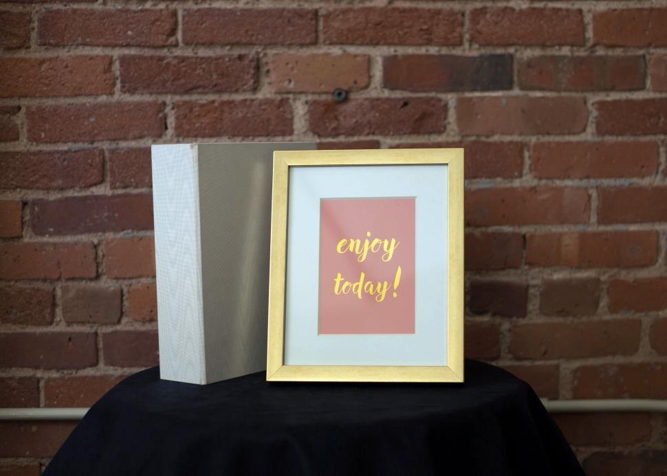 Free Image of Decorative frame with motivational quote against brick wall 