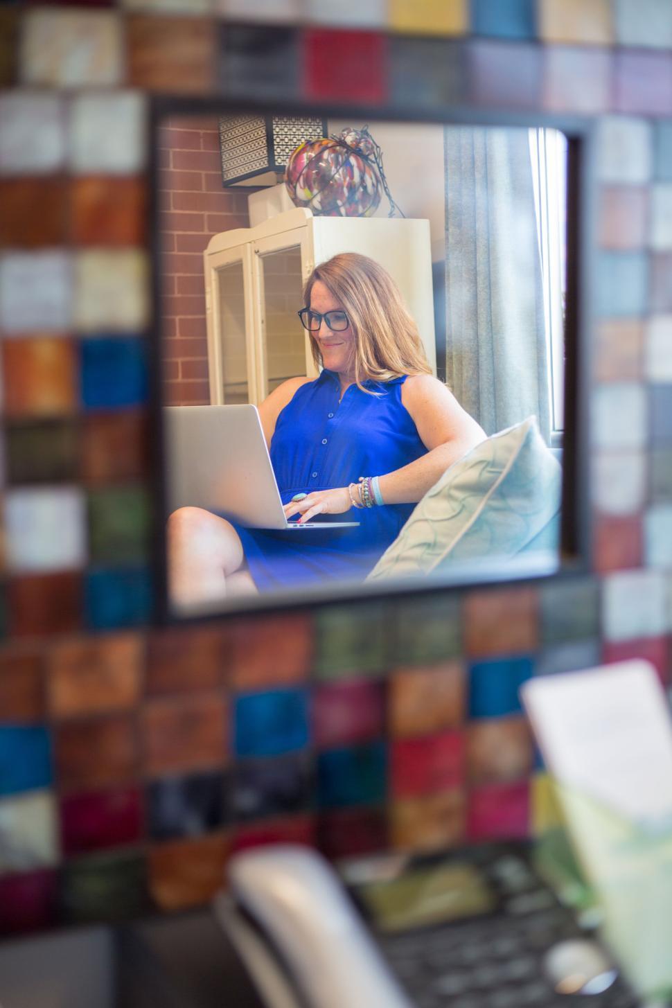 Free Image of Woman working on laptop reflected in colorful tile mirror 