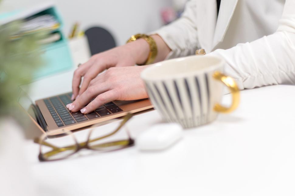 Free Image of Professional working on laptop at modern office desk with coffee mug 