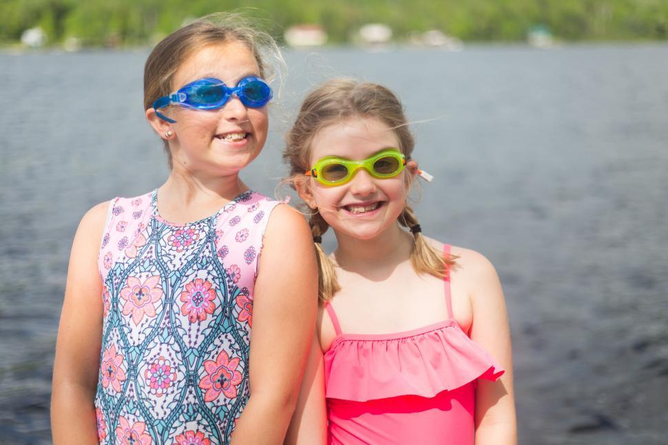 Free Image of Two girls in swimwear and goggles enjoying time by the lake. 