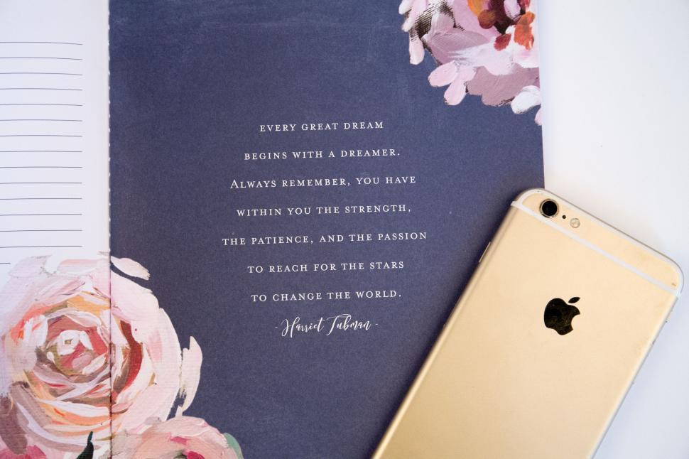Free Image of Inspirational quote from Harriet Tubman beside a gold iPhone on table. 