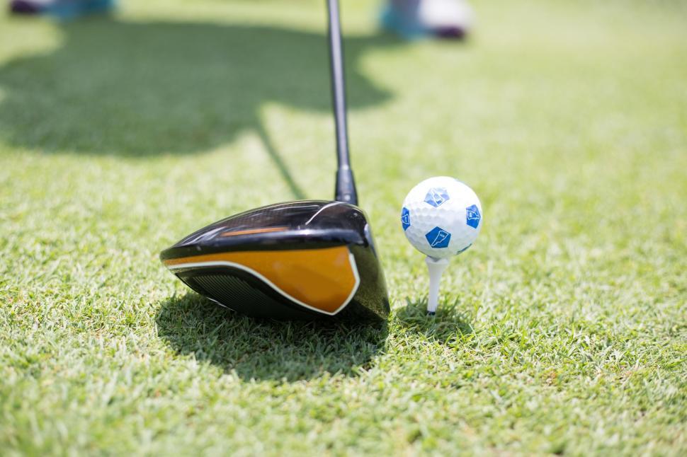 Free Image of Golf club preparing to strike a golf ball on the green grass 