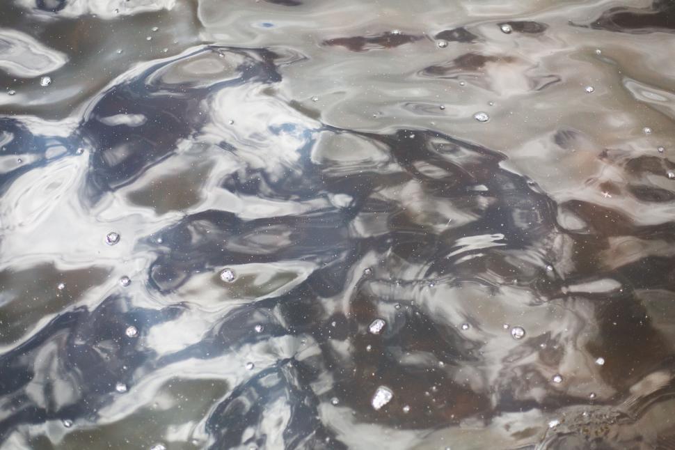 Free Image of Abstract water surface with ripples and reflections of light above. 