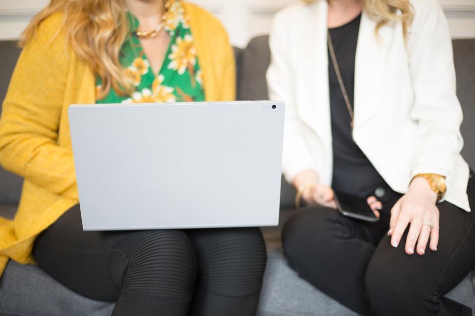 Free Image of Two women working on a laptop in a casual, comfortable setting 