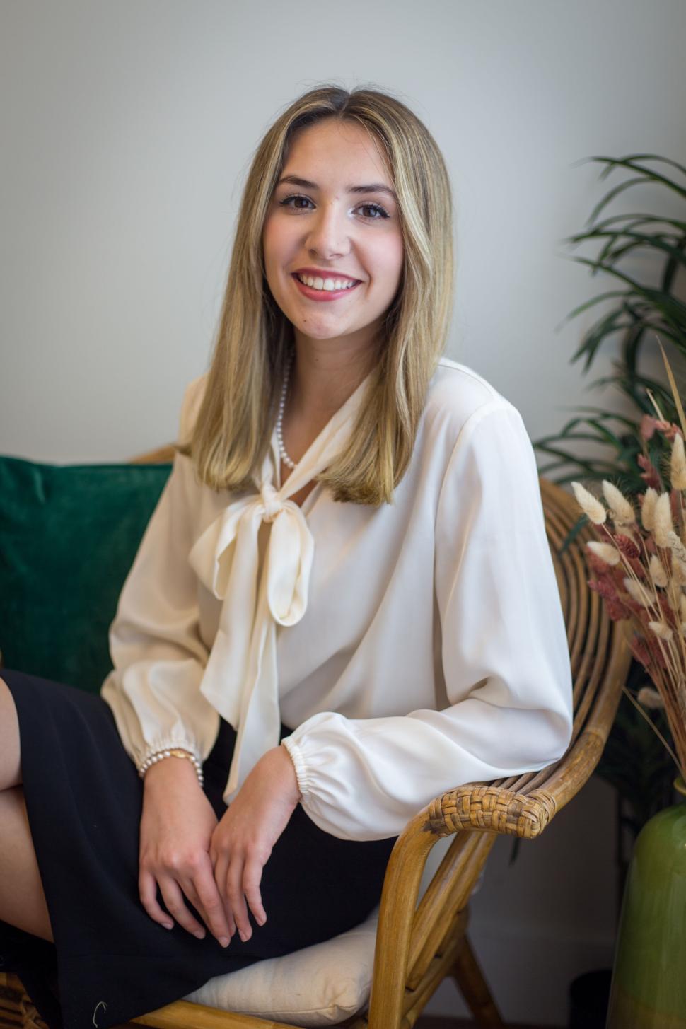 Free Image of Young professional woman seated with a smile in an office. 