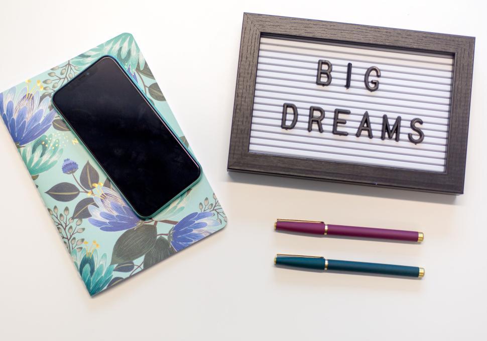 Free Image of Stationery and motivational items on a white desk with phone 