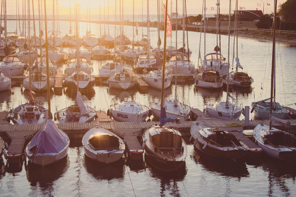 Free Image of Scenic view of a marina at sunrise with boats on a pier 
