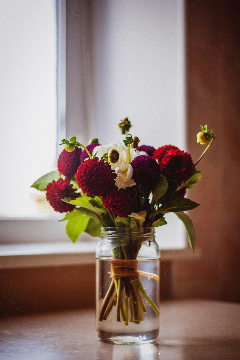 Free Image of Vibrant bouquet of multicolored flowers in a mason jar 
