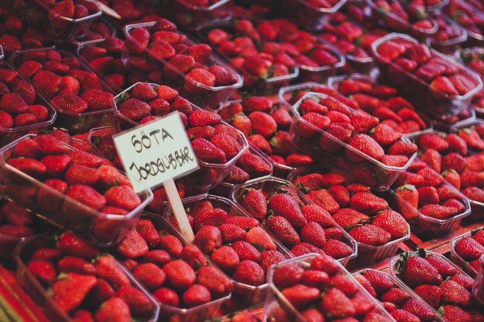 Free Image of A market stall full of fresh strawberries arranged in clear boxes. 