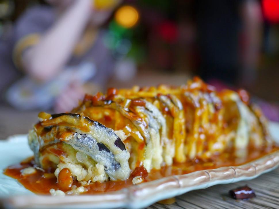 Free Image of Close-up of delicious sushi roll drizzled with savory sauce 