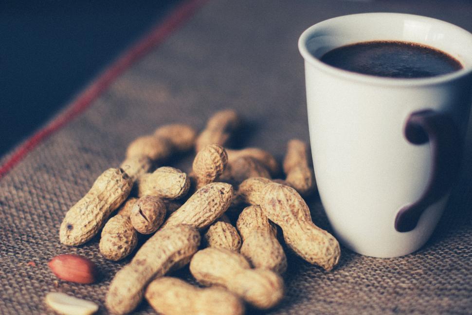Free Image of Cup of black coffee and peanuts on rustic table setting for snack 