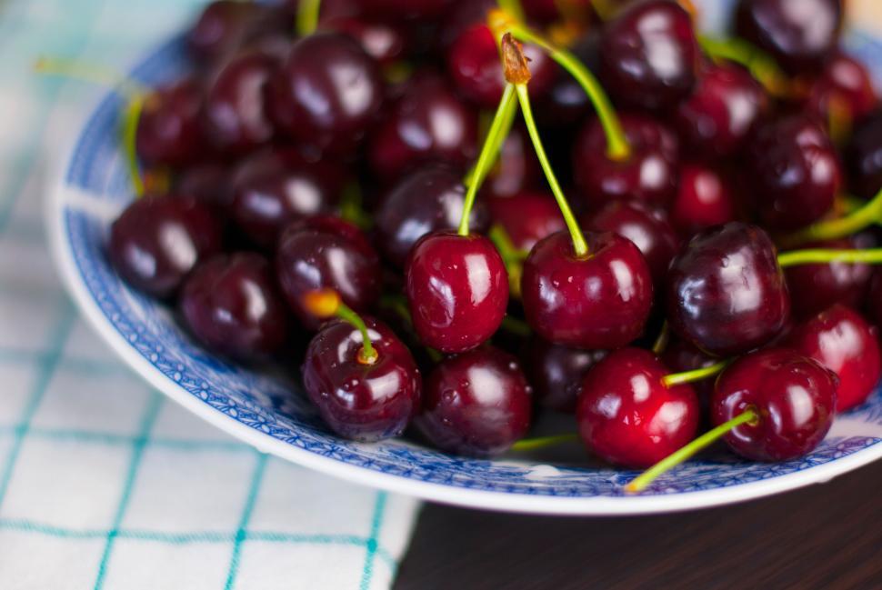 Free Image of A bowl of fresh, luscious ripe cherries piled high on white plate. 