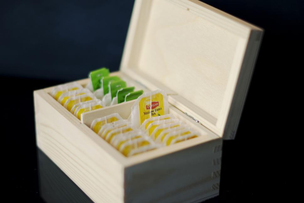 Free Image of Wooden box filled with assorted tea bags for a cozy and warm drink 