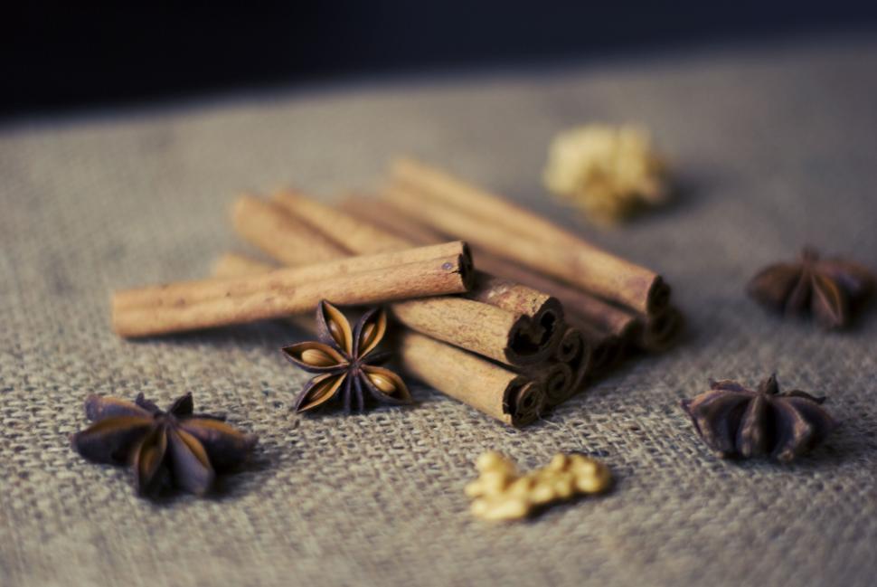 Free Image of Cinnamon sticks and star anise arranged on a mat with spices around. 