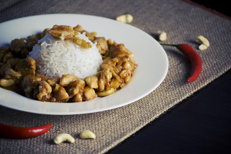 Free Image of Plate of rice with chicken and vegetables, garnished with red chili. 