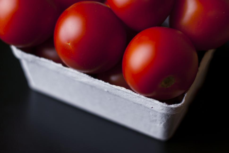 Free Image of Basket filled with ripe red tomatoes on a dark surface background. 