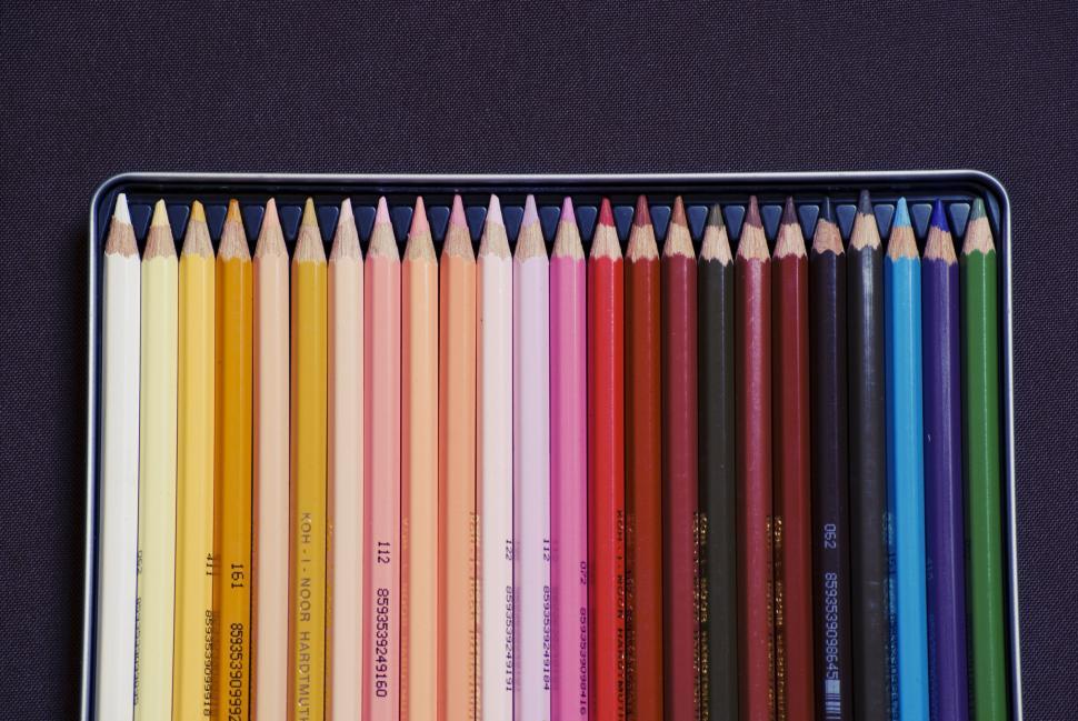 Free Image of Neatly arranged set of colored pencils in a box on a dark surface. 