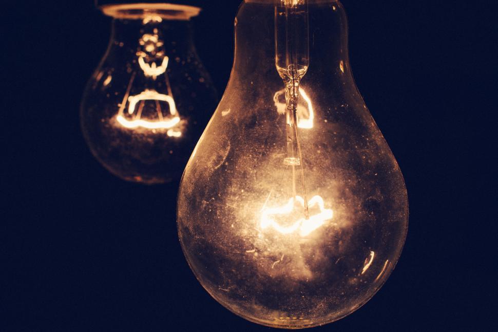 Free Image of Close-up of two glowing incandescent light bulbs in the darkness 