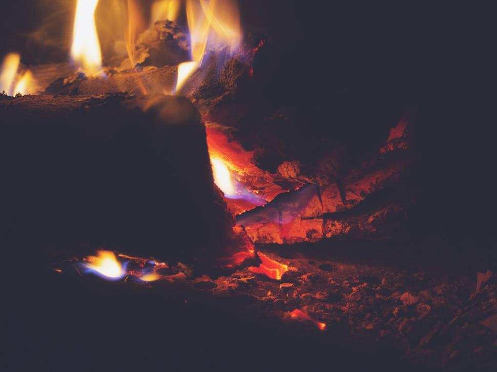 Free Image of Warm glowing embers and flames in a cozy fireplace setting. 